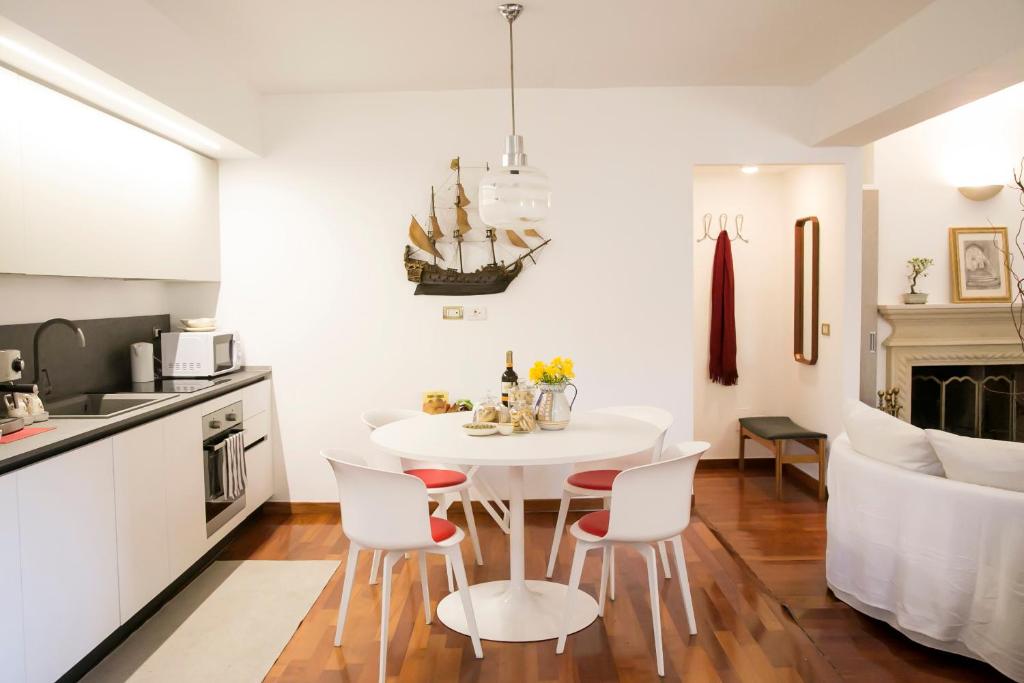 una cucina bianca con tavolo e sedie bianchi di L'angolo sul Parco - Suite a Matera