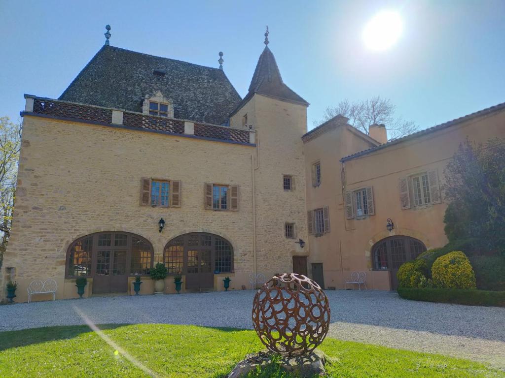 un gran edificio con una estatua delante de él en Château de la Venerie, en Denicé