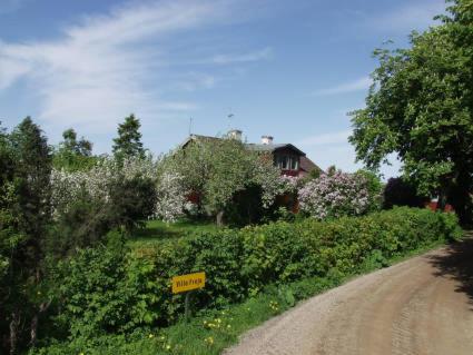 un chemin de terre avec un panneau à côté d'une maison dans l'établissement Villa Freja, à Linköping