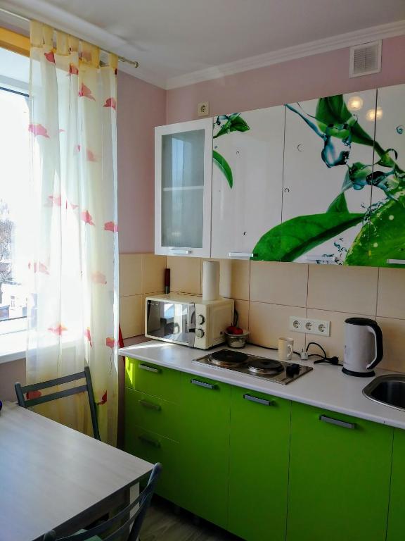 a kitchen with green cabinets and a counter top at Liudmila in Liepāja