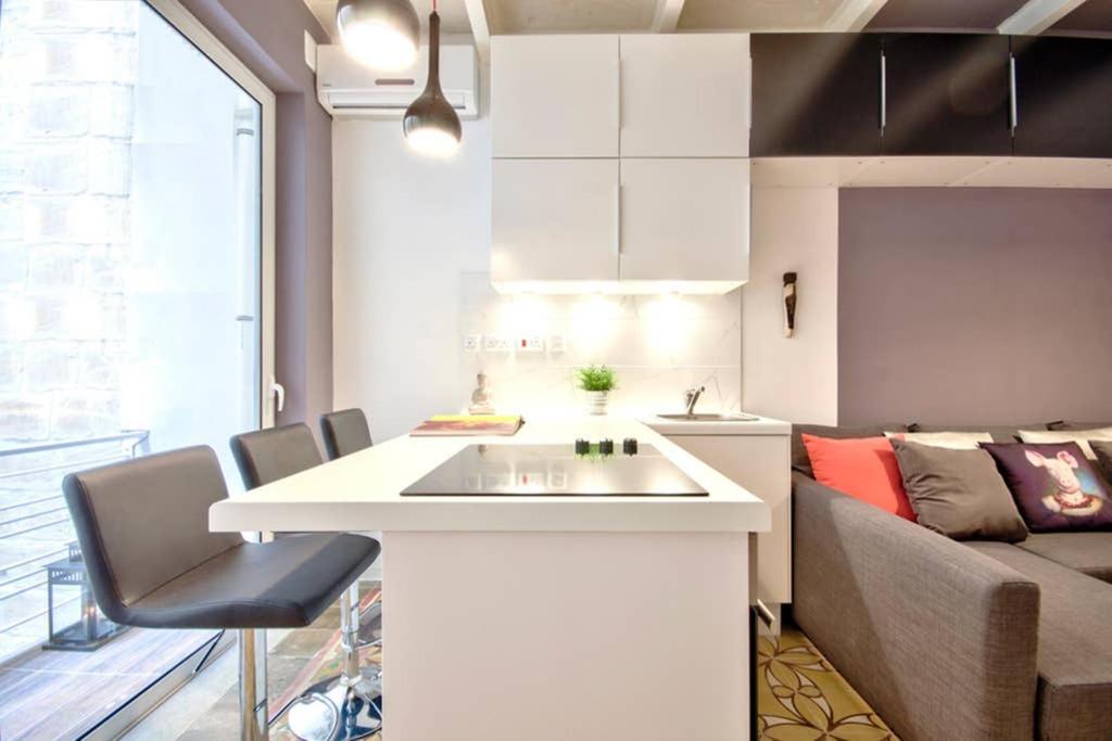 eine Küche und ein Wohnzimmer mit einem Waschbecken und einem Sofa in der Unterkunft Valletta Maison d'art - Centre APT in Valletta