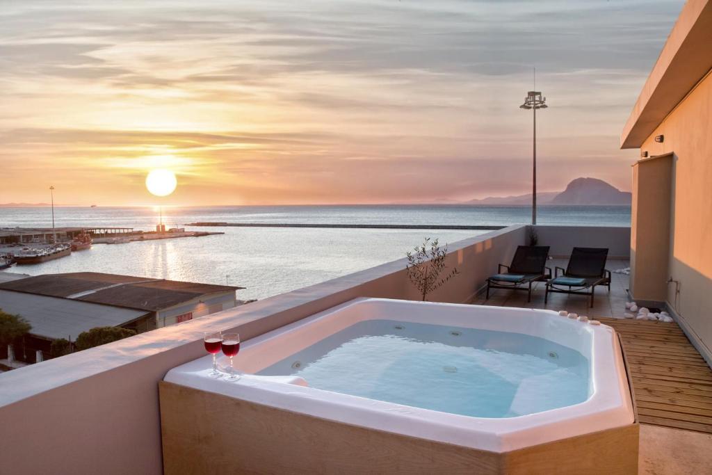 a hot tub on the balcony of a building with the beach at Majestic Penthouse in the heart of Patra in Patra