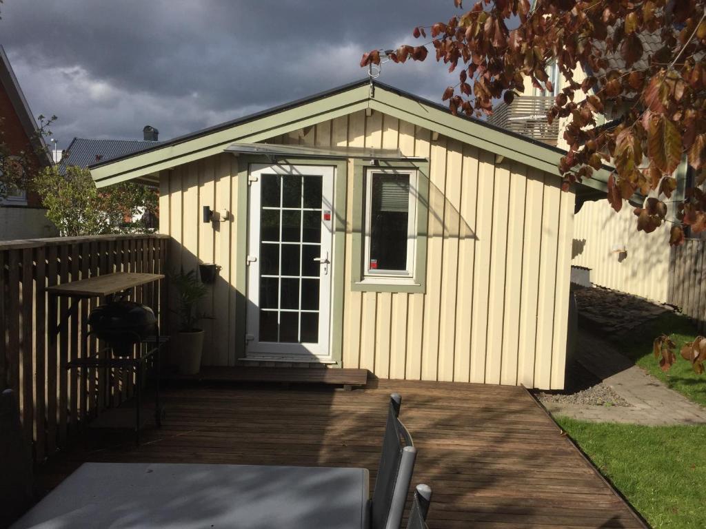 cobertizo pequeño con puerta y terraza de madera en stuga skrea strand en Falkenberg