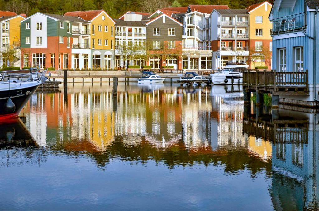 a group of houses and boats in a body of water at Precise Resort Marina Wolfsbruch in Kleinzerlang