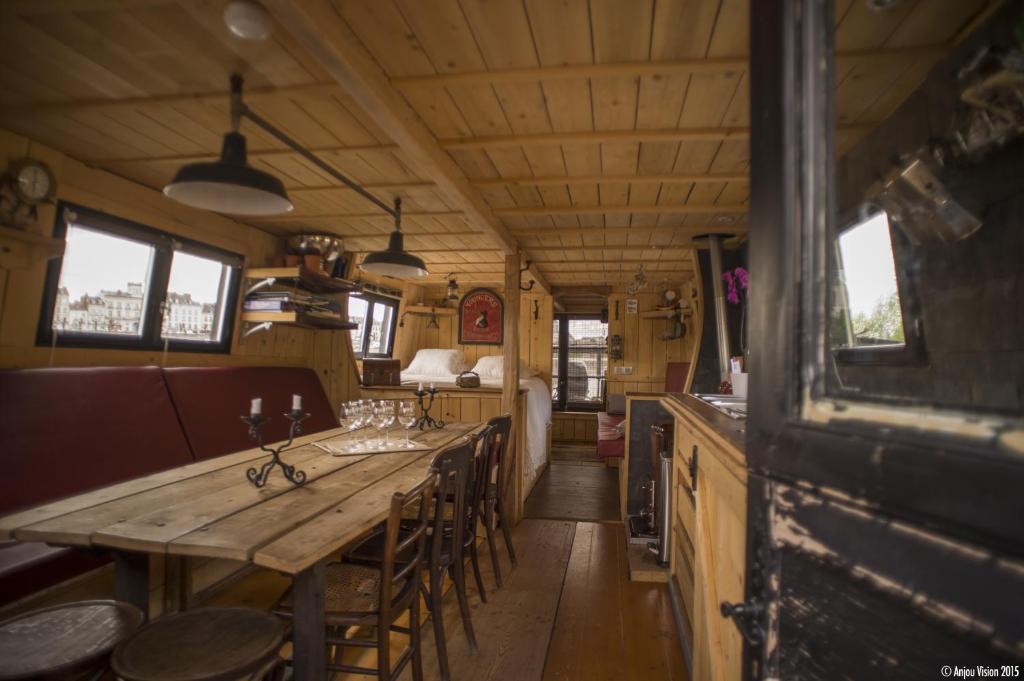 - une salle à manger avec une table et des chaises en bois dans l'établissement BATEAU LE VENT DE TRAVERS, à Saumur