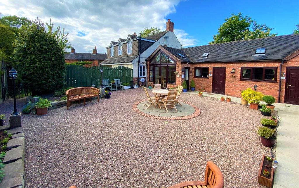 a patio with a table and chairs and a house at High View Cottage in Uttoxeter
