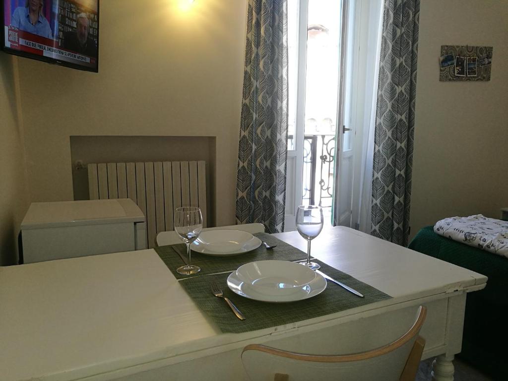 een tafel met twee borden en wijnglazen erop bij Borgoanticoview in Bari