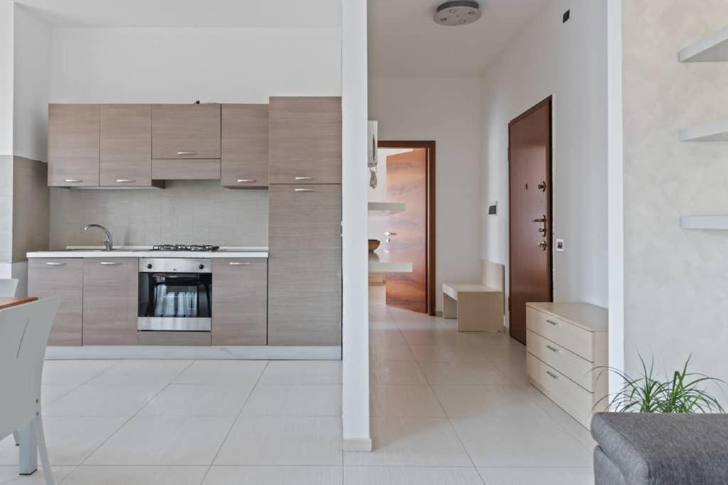 a kitchen with wooden cabinets and a stove top oven at Modern and new apartment in Brianza in Vimercate