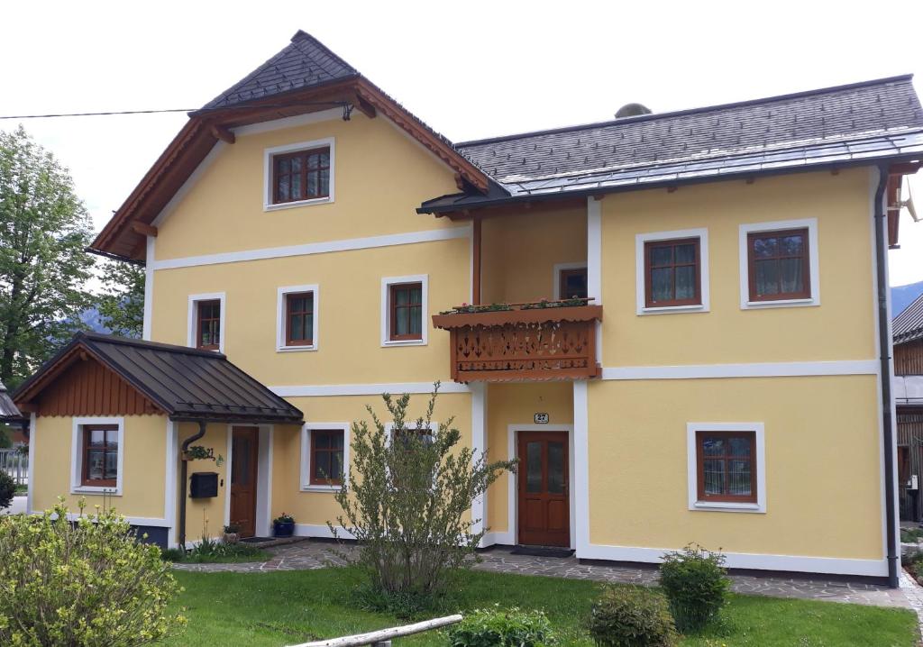una casa gialla con tetto nero di Haus Trausner a Hallstatt