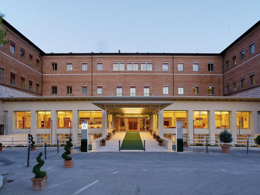 a large brick building with a courtyard in front of it at Domus Pacis Assisi in Assisi