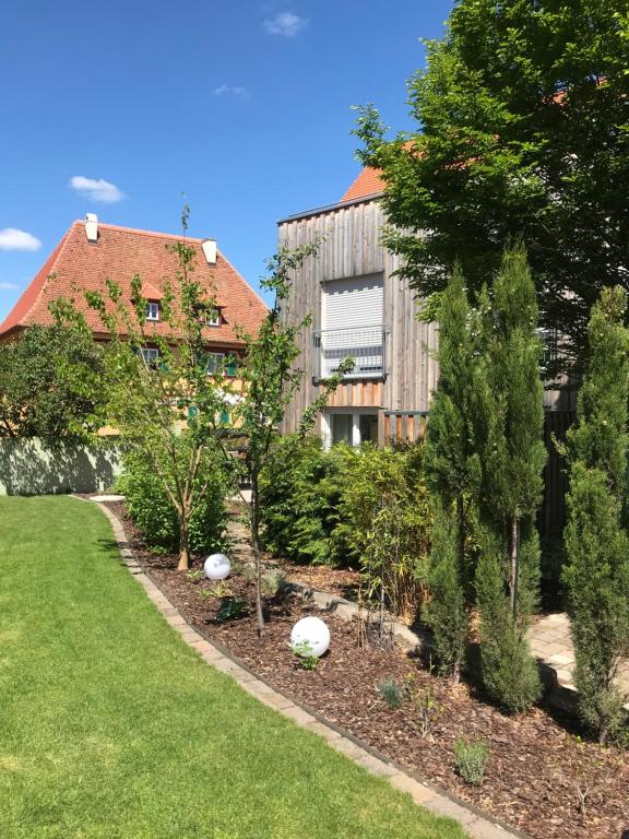 a garden with trees and a building in the background at Große Prinzessin - Appartement mit Saunanutzung in Burgbernheim