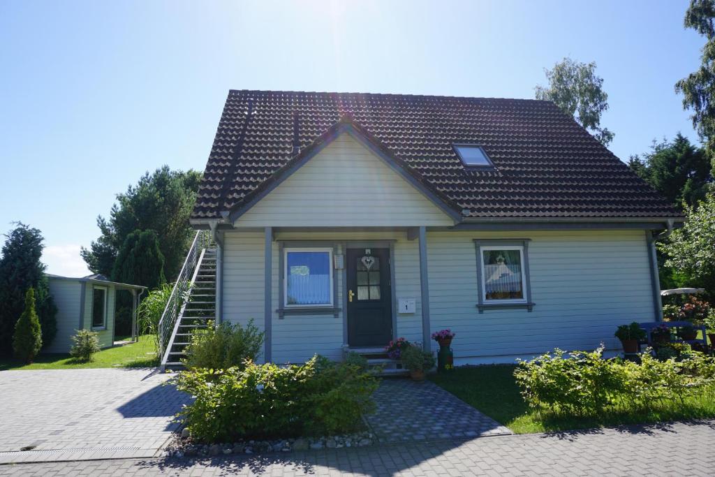 una pequeña casa azul con una puerta negra en Ferienwohnung Ostseebad Karlshagen, en Ostseebad Karlshagen