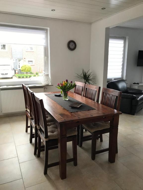 una mesa de madera y sillas en la sala de estar. en Dat Sottje Huus, en Wilhelmshaven