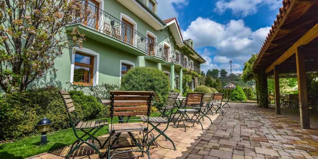 a group of chairs sitting outside of a building at Penzion Tematin in Piešťany