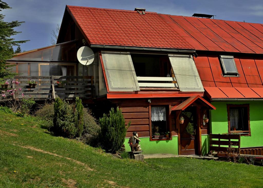 une maison verte et rouge avec un toit rouge dans l'établissement Ubytování pod Rozhlednou, à Velké Karlovice