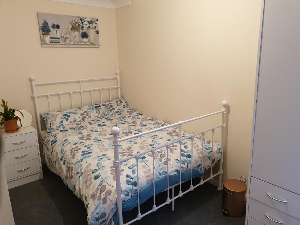 1 dormitorio con 1 cama con edredón azul y blanco en Chatham Private Rooms en Chatham
