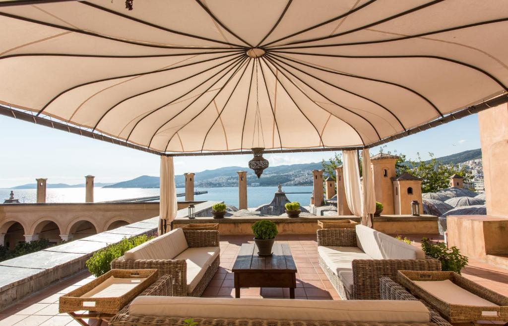 a large umbrella on a patio with chairs and a table at Imaret in Kavála
