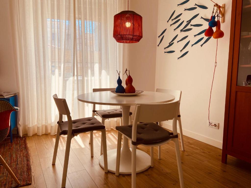 uma sala de jantar com uma mesa, cadeiras e um candeeiro em Enjoy Casa do Forte Apartment em Lisboa