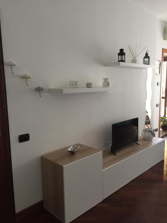 salon z telewizorem na białej ścianie w obiekcie Dali House Airport And Fiera w mieście Fiumicino