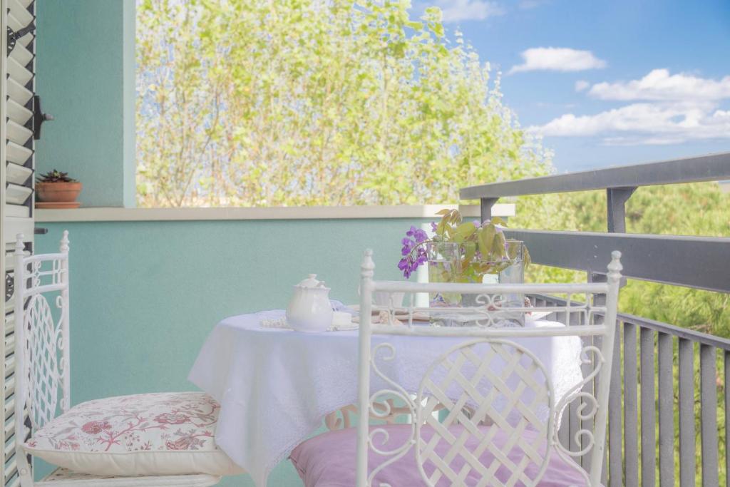 un tavolo bianco e sedie su un balcone di Sirena Apartment a Riccione