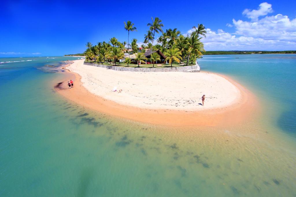 an island in the ocean with people on a beach at Arraial D'ajuda Eco Resort in Arraial d'Ajuda