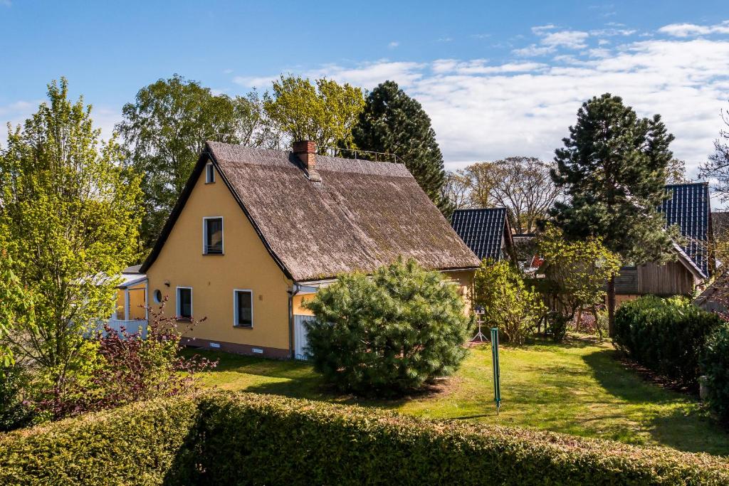 una pequeña casa amarilla con techo en Darßer Koje, en Wieck
