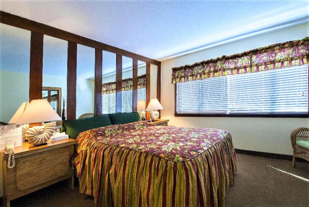 a bedroom with a bed and a large window at Royal Holiday Beach Resort in Biloxi