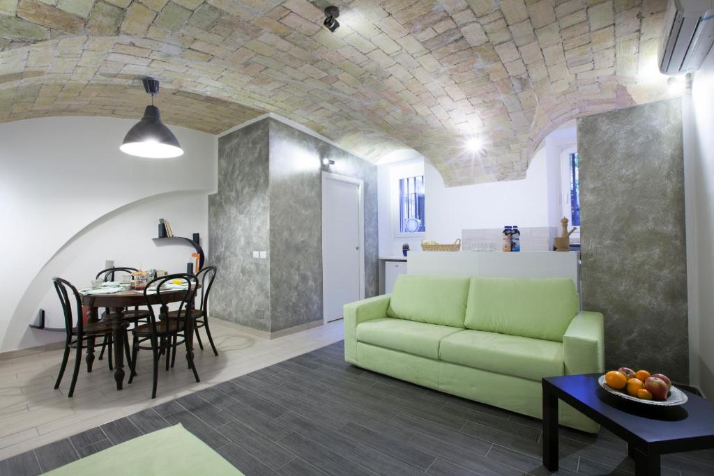 ein Wohnzimmer mit einem grünen Sofa und einem Tisch in der Unterkunft Guesthouse Sant'Angelo in Rom