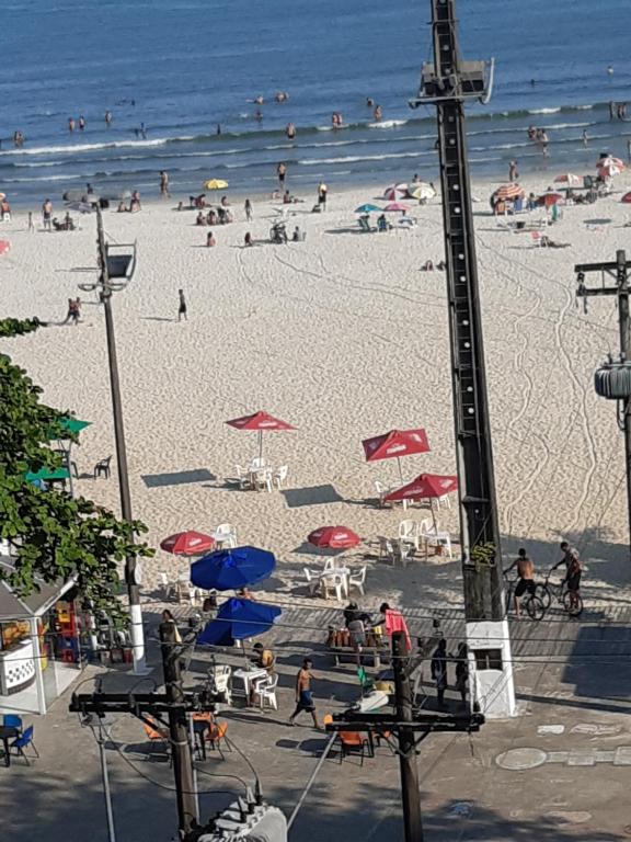 uma praia com muita gente e o oceano em APARTAMENTO EM SÃO VICENTE - SP em São Vicente