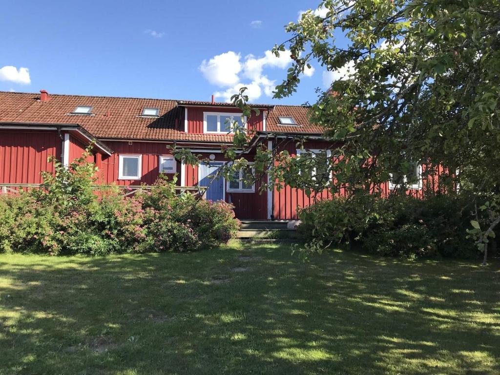 uma casa vermelha com um quintal em frente em Vandrarhem Varvet em Ellös