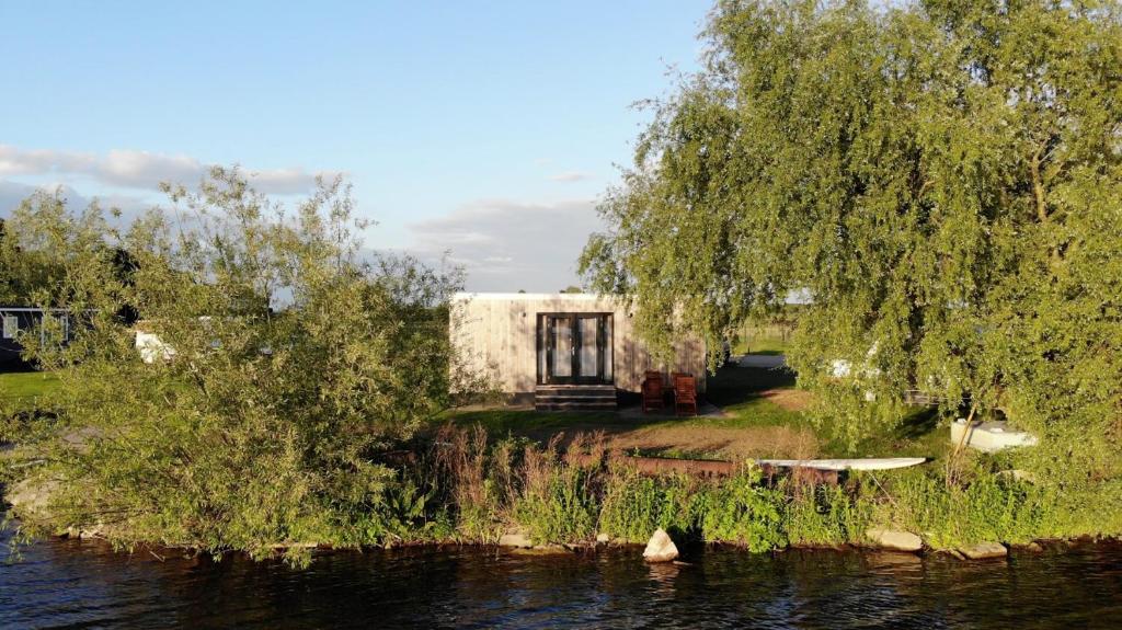 a house on the shore of a river at Tiny House by the water - de Schans Alphen in Alphen