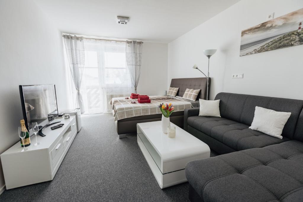 een woonkamer met een bank en een bed bij Apartmán 15 MyMara in Bešeňová