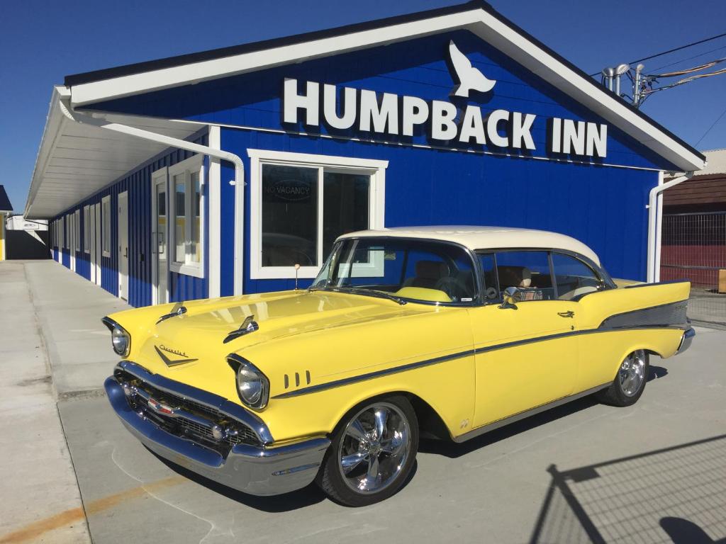 un'auto gialla parcheggiata di fronte a una locanda per la sosta delle carrozze di Humpback Inn a Port McNeill