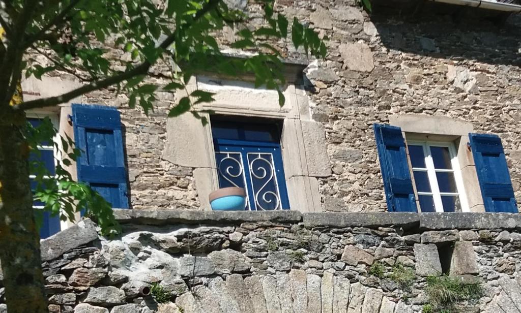 a window with blue shutters on a stone building at Domaine d'Angel-Berg in Vézins-de-Lévézou