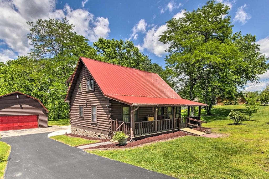 a log cabin with a red roof and a barn at Rustic Cabin with Screened Deck 8 Mi to Dollywood in Sevierville