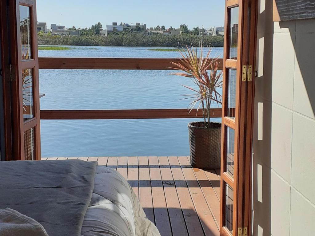 a bedroom with a view of the water from a balcony at Pousada Águas do Mampituba in Torres