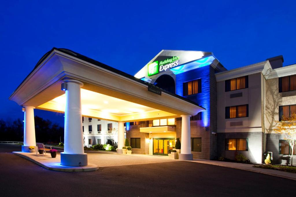 a hotel with a lit up building at night at Holiday Inn Express Syracuse Airport, an IHG Hotel in North Syracuse