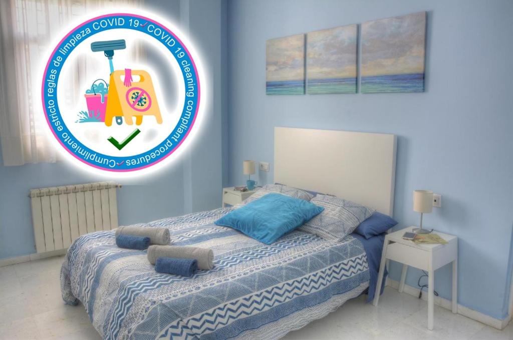 セビリアにあるSEVILLA BUTTERFLY SUITESの青いベッドルーム(ベッド1台、上に看板付)