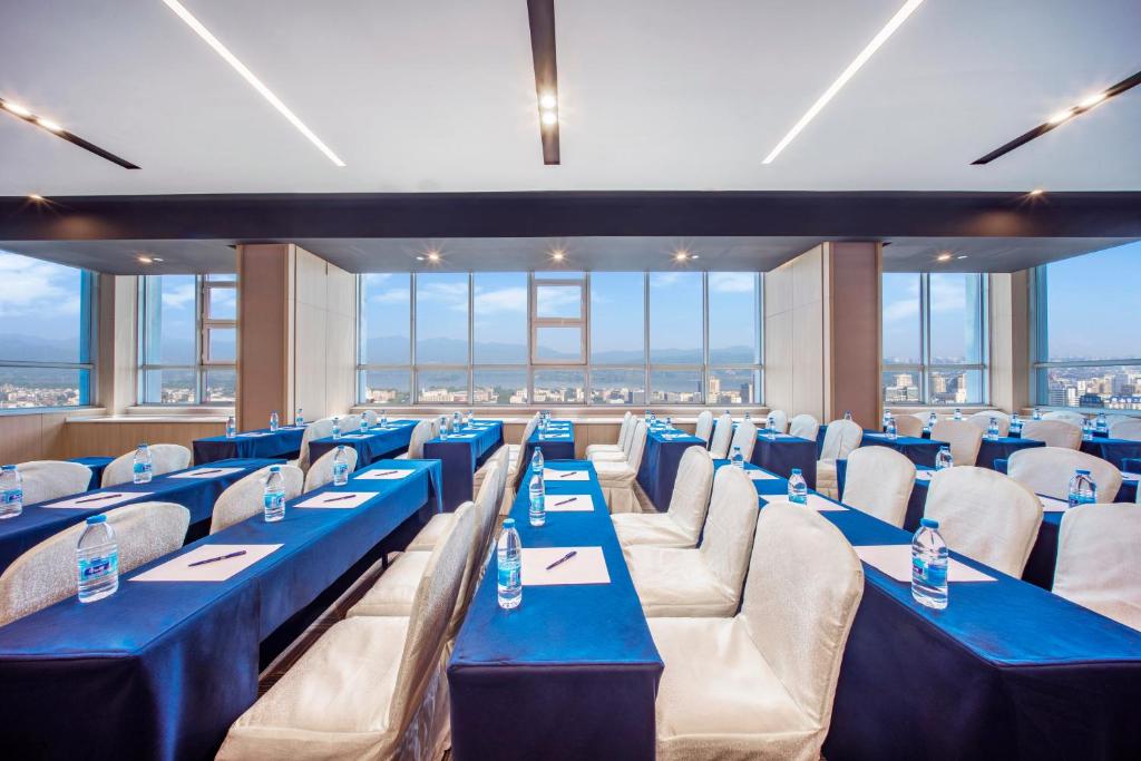 杭州市にあるHoliday Inn Express Hangzhou Westlake East by IHGの青いテーブルと椅子、窓が備わる客室です。