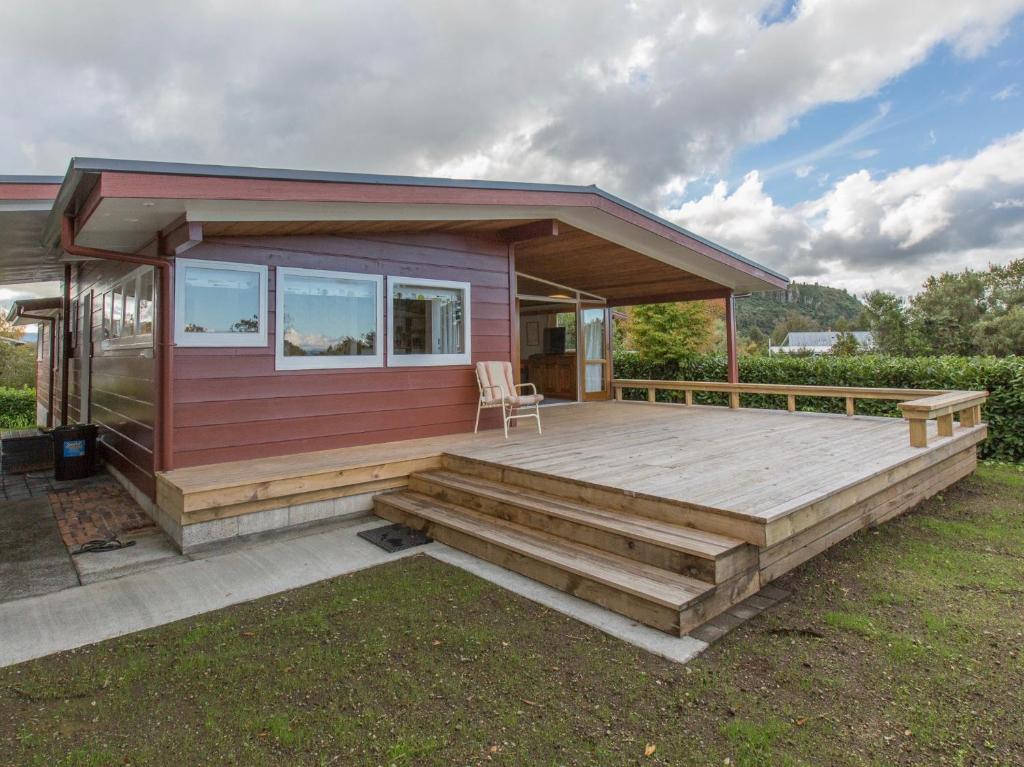 una casa modular con terraza y casa en Sixties Cedar Bach - Kuratau Holiday Home, en Kuratau