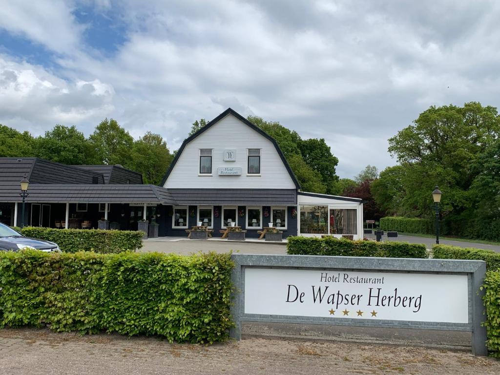 un edificio con una señal delante de él en De Wapser Herberg, en Wapse