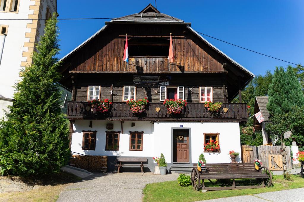 abweichendes Haus mit einer Bank davor in der Unterkunft Landhaus Alpentraum in Kaning