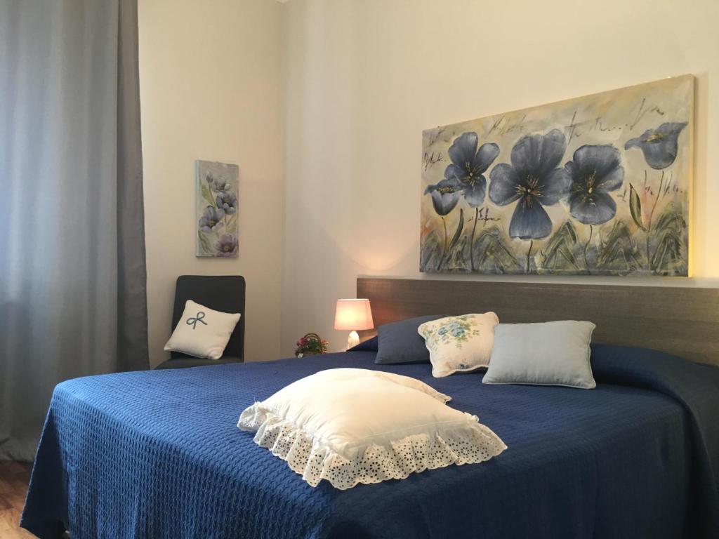 een slaapkamer met een blauw bed en een schilderij aan de muur bij Appartamenti del Corso in Cuneo