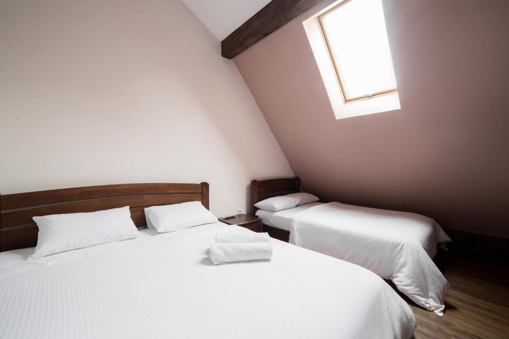 1 Schlafzimmer mit 2 weißen Betten und einem Fenster in der Unterkunft Apartments on Mitny Square in Lwiw