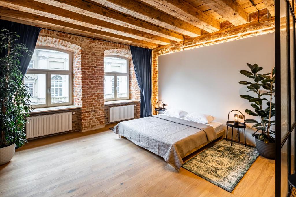 - une chambre avec un lit et un mur en briques dans l'établissement OnLviv Apartments Rynok Square 18, à Lviv