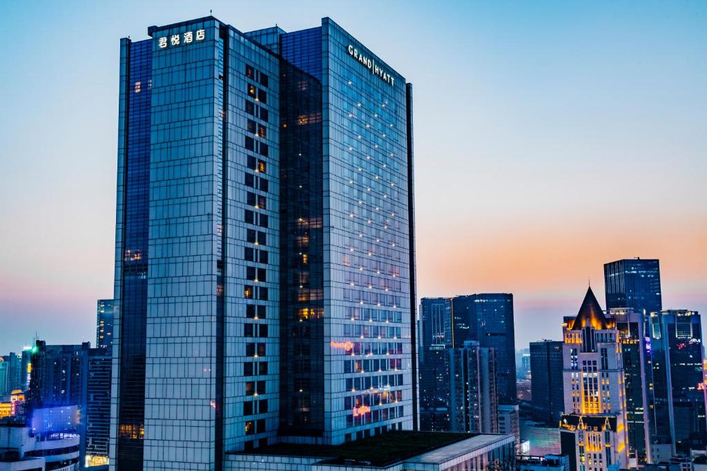 a tall glass building in front of a city at Grand Hyatt Chengdu in Chengdu