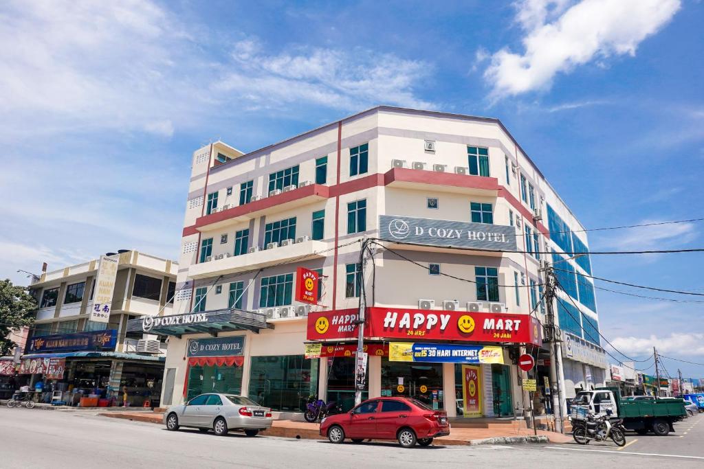 a building with cars parked in front of a street at DCozy Hotel in Perai