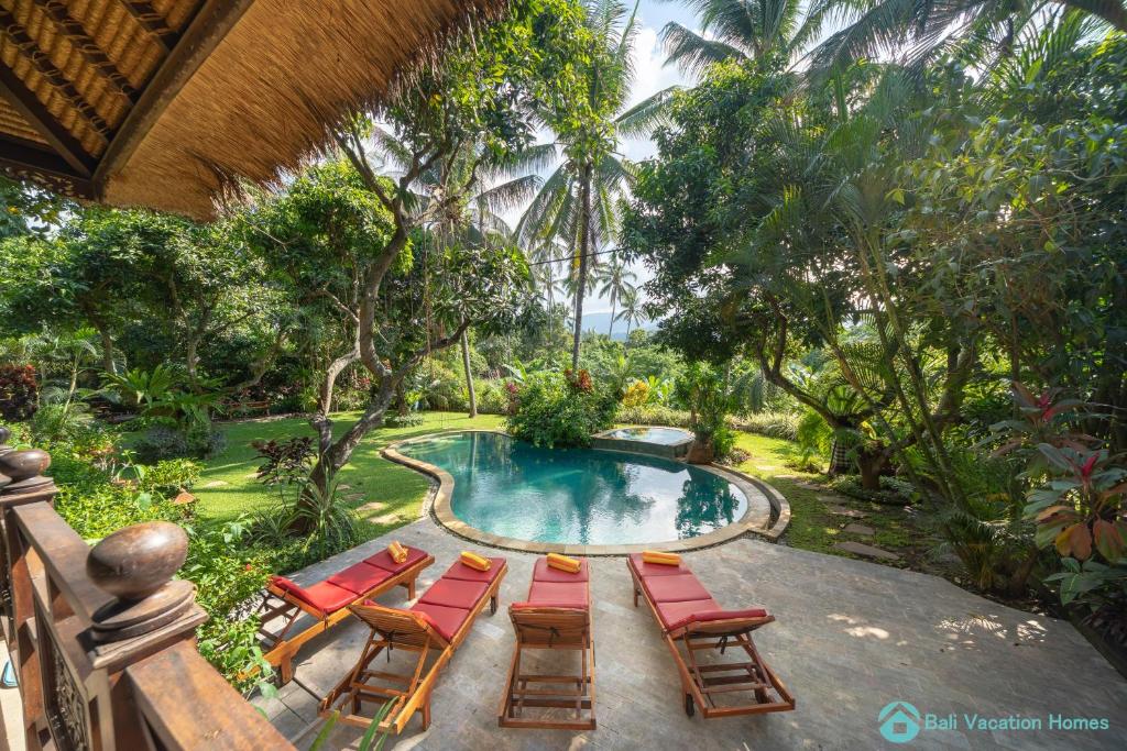 een groep stoelen en een zwembad bij Wonderful luxury hideaway surrounded by nature in Mayong