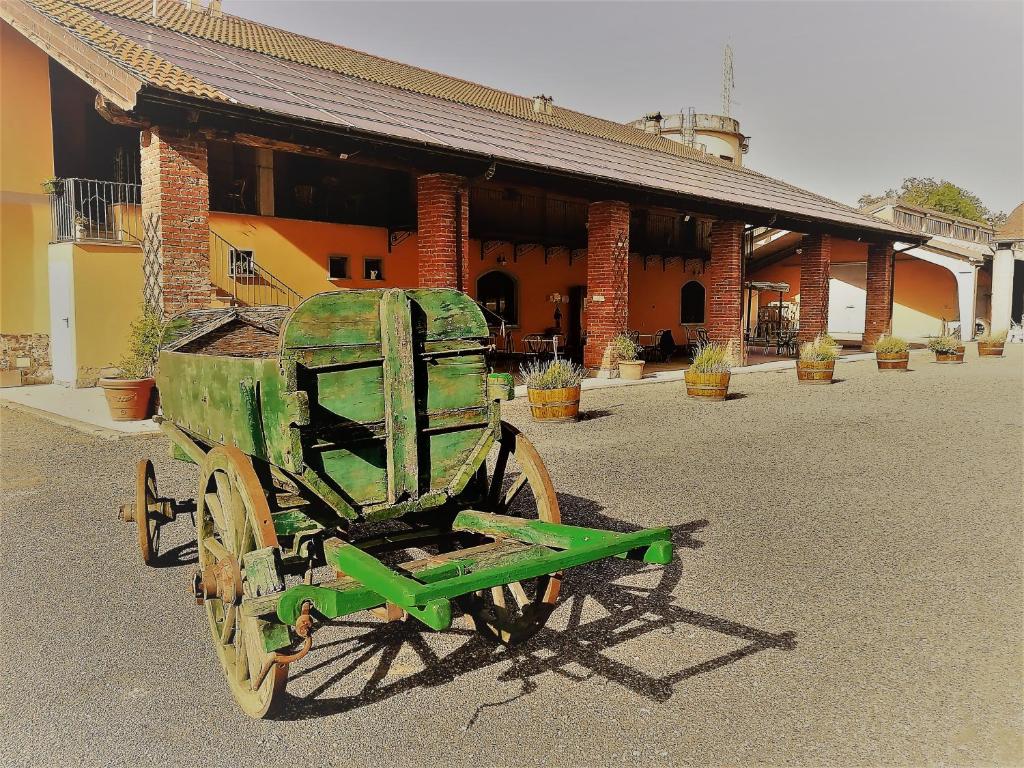 um velho carrinho verde sentado em frente a um edifício em Country House Cascina Orto em Pasturana