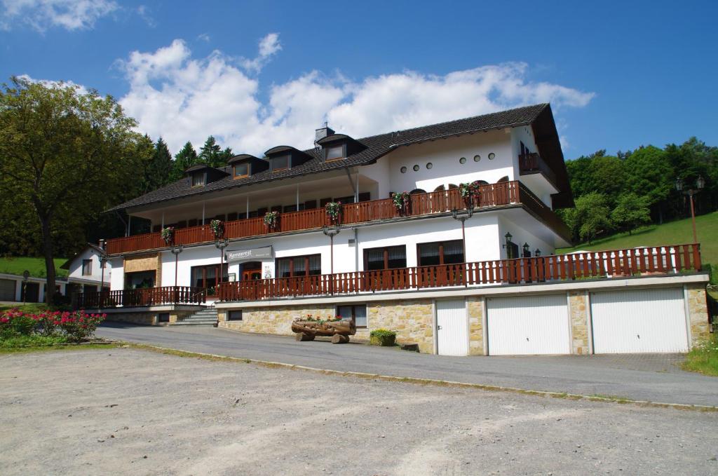 - un grand bâtiment avec un balcon sur le côté dans l'établissement Hotel Herrenrest, à Georgsmarienhütte